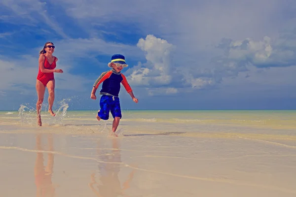 Madre e figlio in esecuzione sulla spiaggia tropicale — Foto Stock