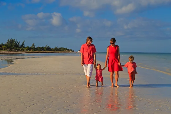 Jonge gezin met twee kinderen lopen op strand — Stockfoto
