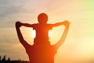 Baba ve oğul günbatımında oynama