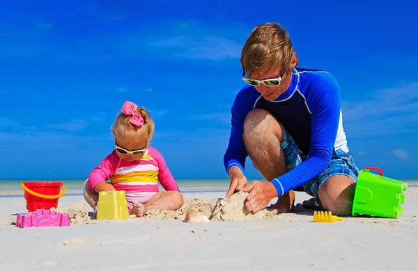 Apa és játék-val homok a strandon a kislányom — Stock Fotó