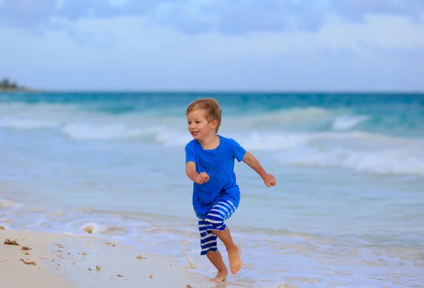 Gelukkig jongetje lopen op zand strand — Stockfoto