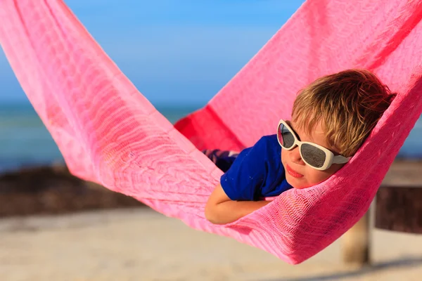 Menino relaxado em rede na praia — Fotografia de Stock