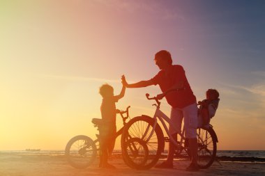 Motorcu aile siluet, Bisiklet üzerinde iki çocuk ile baba