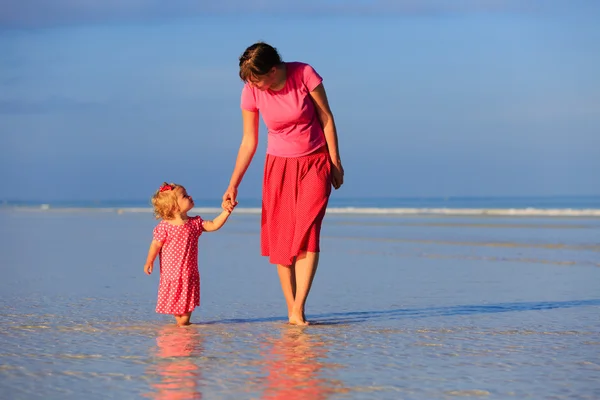 Moeder en dochtertje wandelen op het strand — Stockfoto