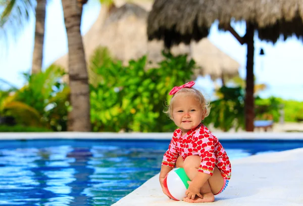 Cute toddler girl playing with ball in swimming pool — Stock Photo, Image