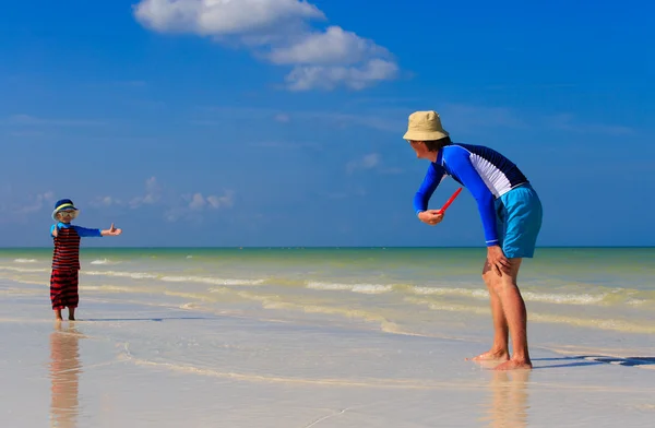 Padre e hijo jugando con disco volador en la playa — Foto de Stock