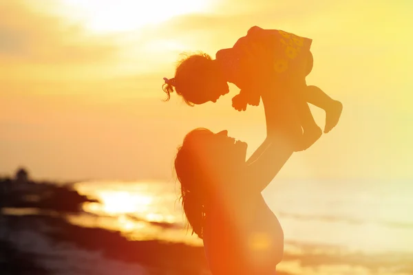 Mère et petite fille jouent au coucher du soleil — Photo
