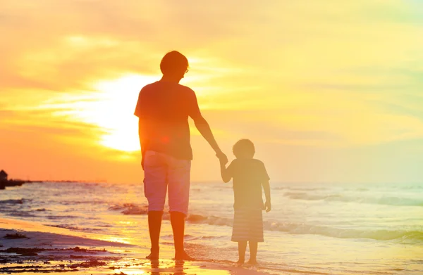 Vader en zoon hand in hand bij zonsondergang — Stockfoto