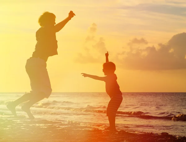 Père et fils sautant au coucher du soleil — Photo