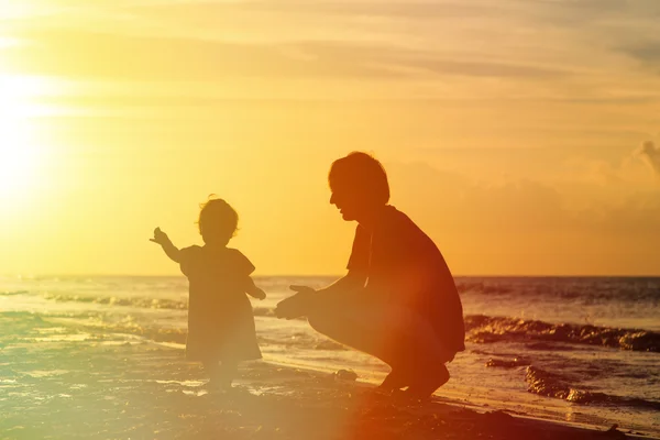 Siluetas de padre e hija pequeña al atardecer — Foto de Stock