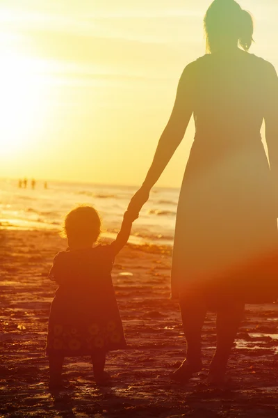Matka a malá dcera procházky při západu slunce — Stock fotografie