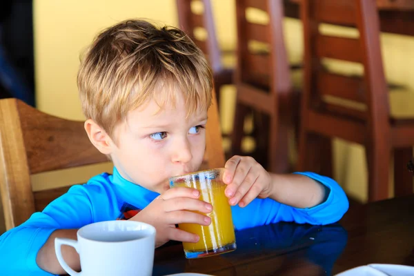 Lindo niño bebiendo jugo en la cafetería — Foto de Stock