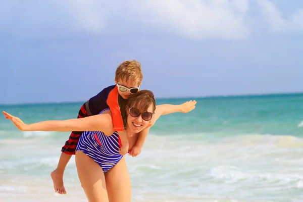 Mother and son flying on the beach — Stock Photo, Image