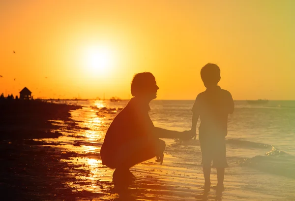Отец и сын держатся за руки на закате — стоковое фото