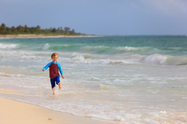 mutlu küçük çocuk kum plajı üzerinde çalışan