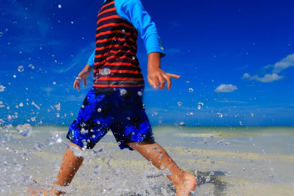 Malý chlapec hraje s vodou na letní beach — Stock fotografie