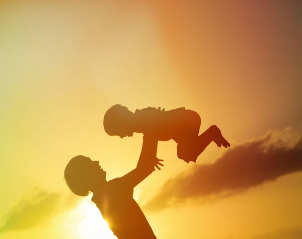 Otec a syn siluety hrát při západu slunce — Stock fotografie