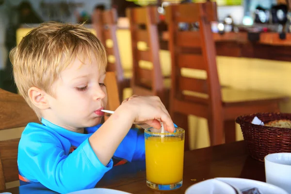 Lindo niño bebiendo jugo en la cafetería — Foto de Stock