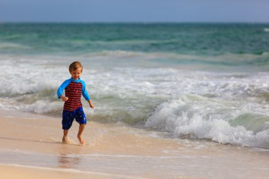 mutlu küçük çocuk kum plajı üzerinde çalışan