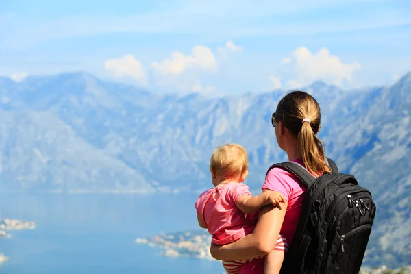 Mor med lilla dotter tittar på berg — Stockfoto