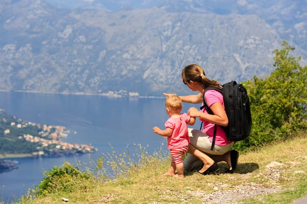 Mor med lilla dotter tittar på berg — Stockfoto