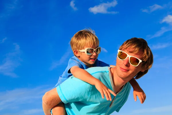 Vader en zoontje spelen op blauwe hemel — Stockfoto