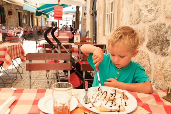 Niño comiendo en la cafetería de la ciudad en el día de verano — Foto de Stock