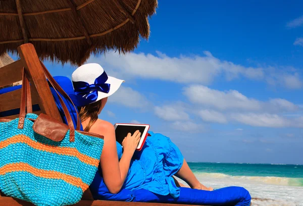 Frau mit Touchpad am tropischen Strand — Stockfoto