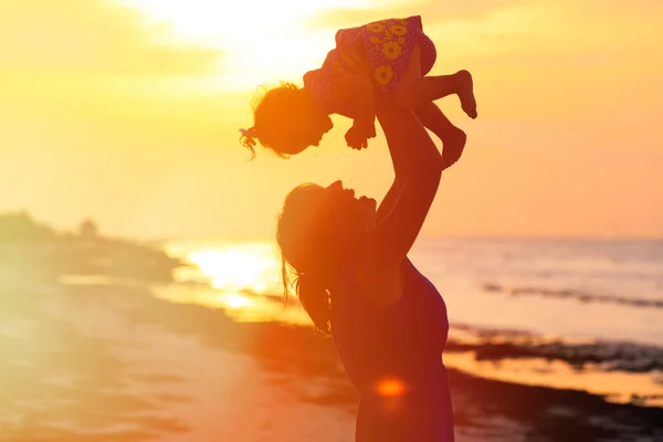 Mutter und kleine Tochter spielen bei Sonnenuntergang — Stockfoto