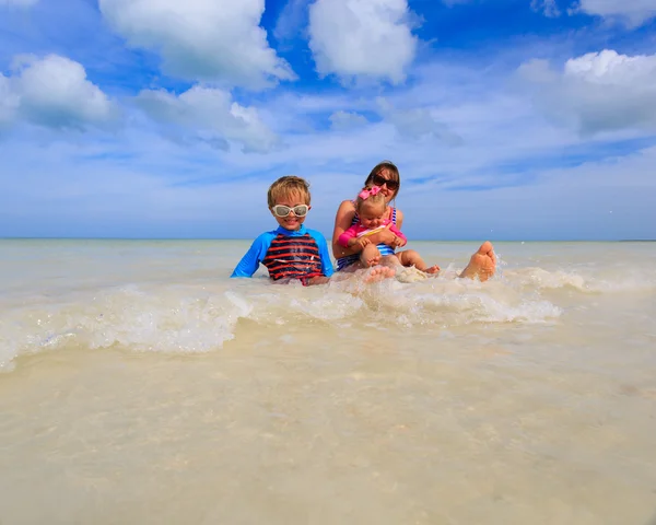 Mother with kids splasing water at the sea — Stock Photo, Image