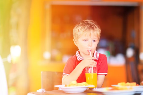 Lindo niño bebiendo jugo en la cafetería — Foto de Stock