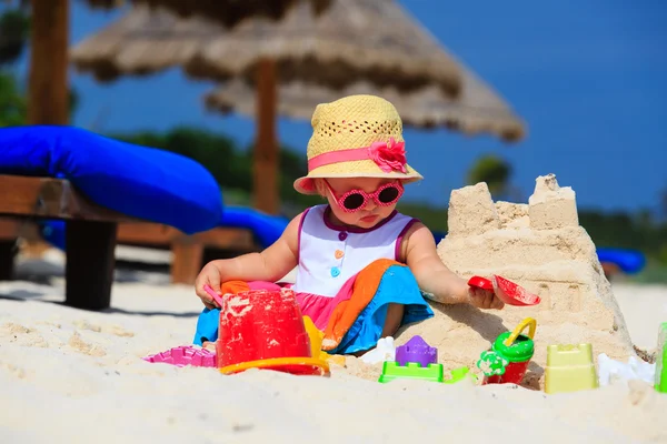 Cute little girl building sandcastle on summer beach — Stock Photo, Image