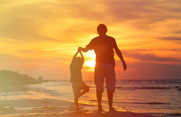 Padre e figlio che fanno yoga al tramonto mare — Foto Stock