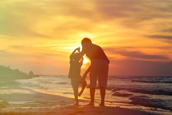 Père et fils faire du yoga au coucher du soleil mer — Photo