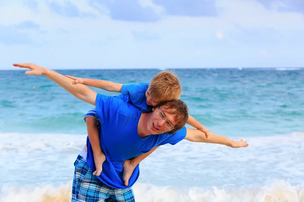 Pai e filho voando na praia — Fotografia de Stock