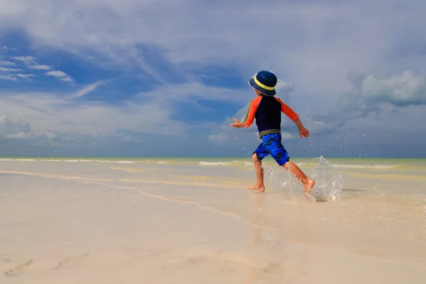 Mały chłopiec cieszyć się działa na lato plaża — Zdjęcie stockowe