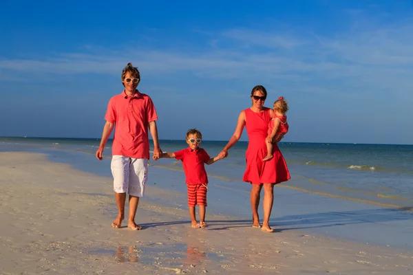 Jeune famille avec deux enfants marchant à la plage — Photo