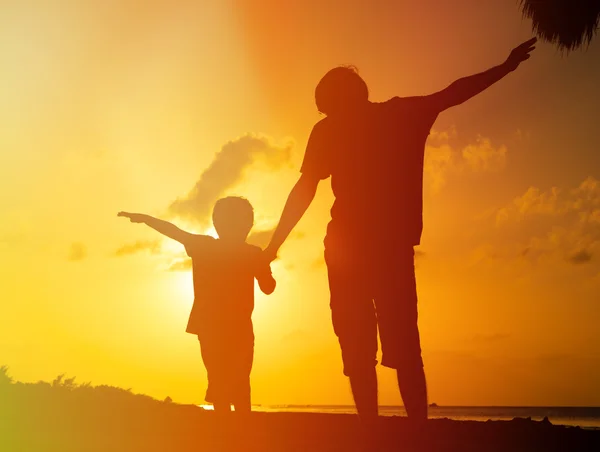 Pai e filho brincam na praia do pôr do sol — Fotografia de Stock