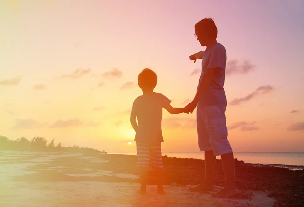 Батько і син на пляжі заходу сонця — стокове фото