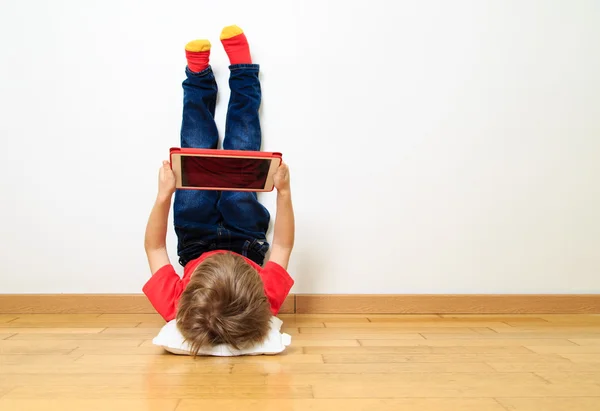 Kleiner Junge schaut auf Touchpad — Stockfoto