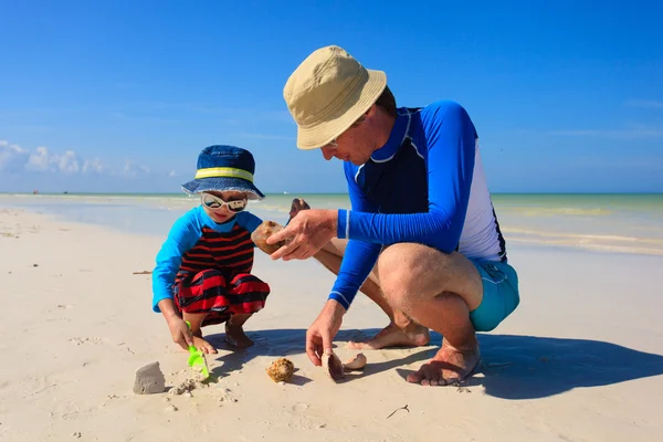 Vader en zoon gebouw zand kasteel op zomer strand — Stockfoto