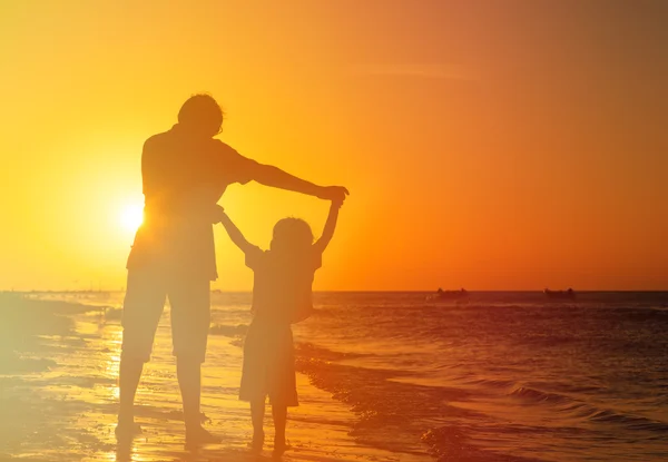 Pai e filho brincam na praia do pôr do sol — Fotografia de Stock