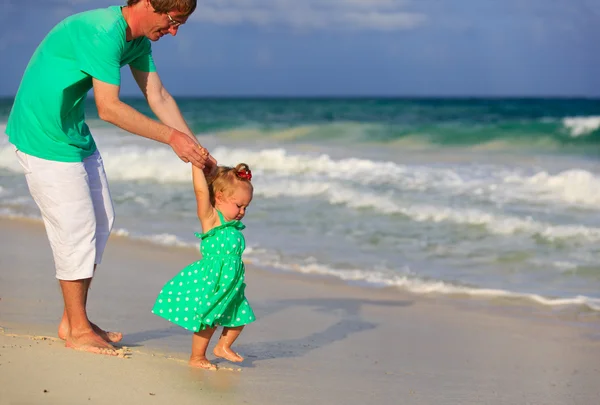 Vader en dochtertje wandelen op het strand — Stockfoto