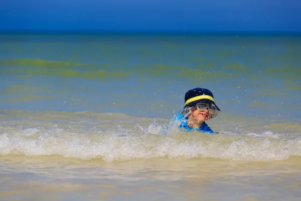Mały chłopiec bawi się fale na plaży — Zdjęcie stockowe
