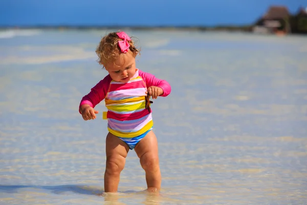 Bambina che tiene stelle marine sulla spiaggia estiva — Foto Stock