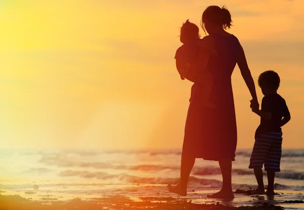 Mother and two kids walking at sunset — Stock Photo, Image