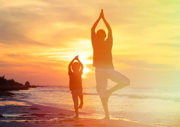 Baba ve oğul gün batımında yoga yaparken