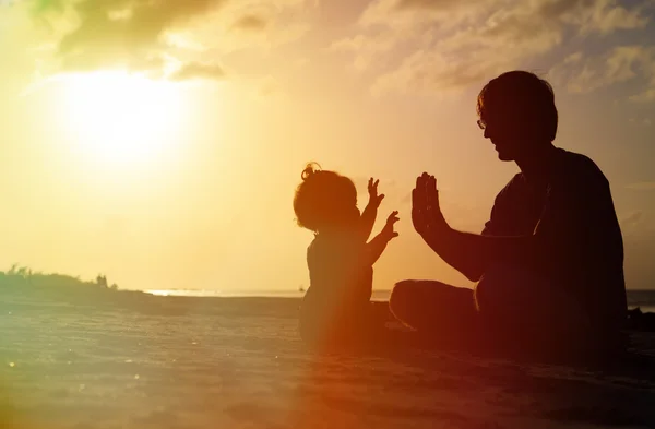 Pai e pequena filha silhuetas ao pôr do sol — Fotografia de Stock