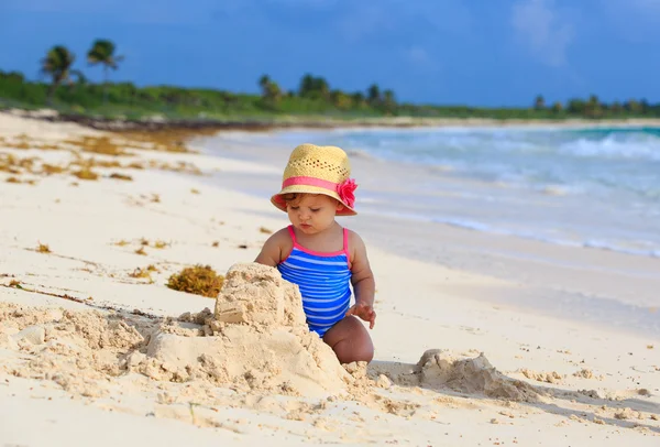 Schattig klein meisje gebouw sandcastle op het strand — Stockfoto