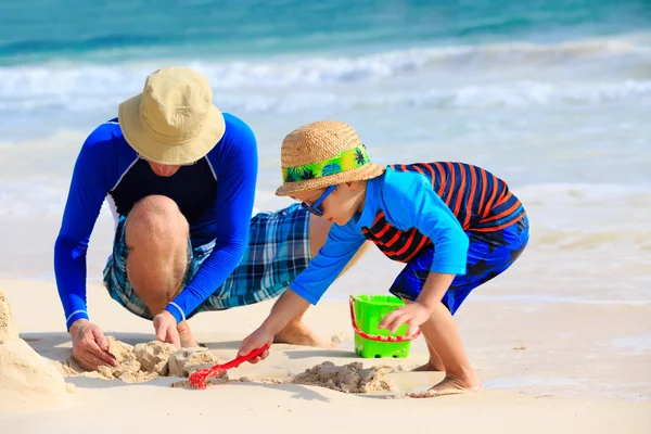 Père et fils construisant le château de sable sur la plage — Photo